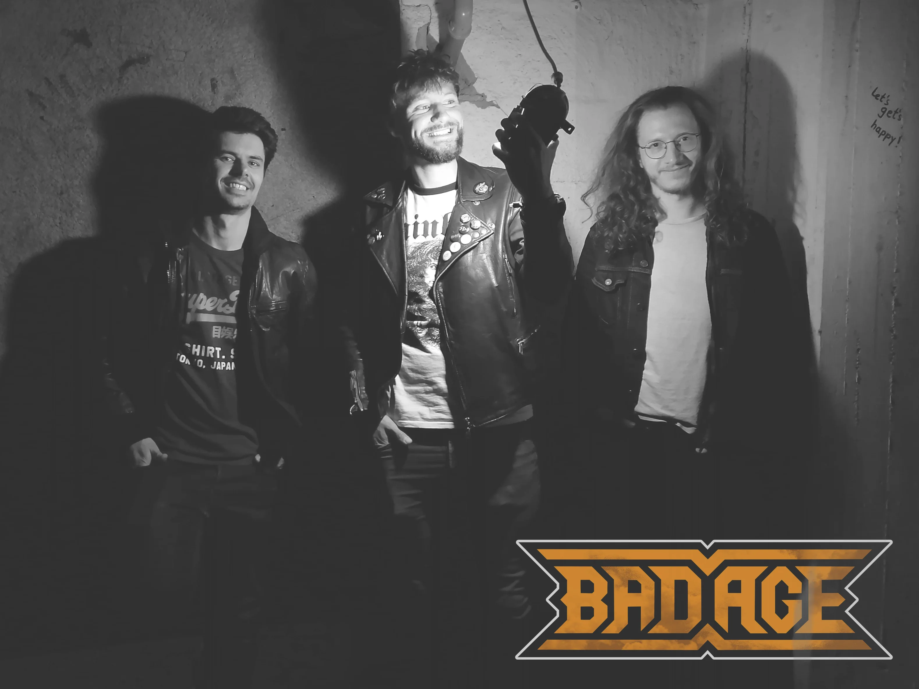 Black and white bandphoto of Bad Age.
Three guys standing in front of a bare wall. Lighted by a cellar lamp the middle one is holding in his hand, facing it.
In the lower right corner is the band logo of Bad Age.