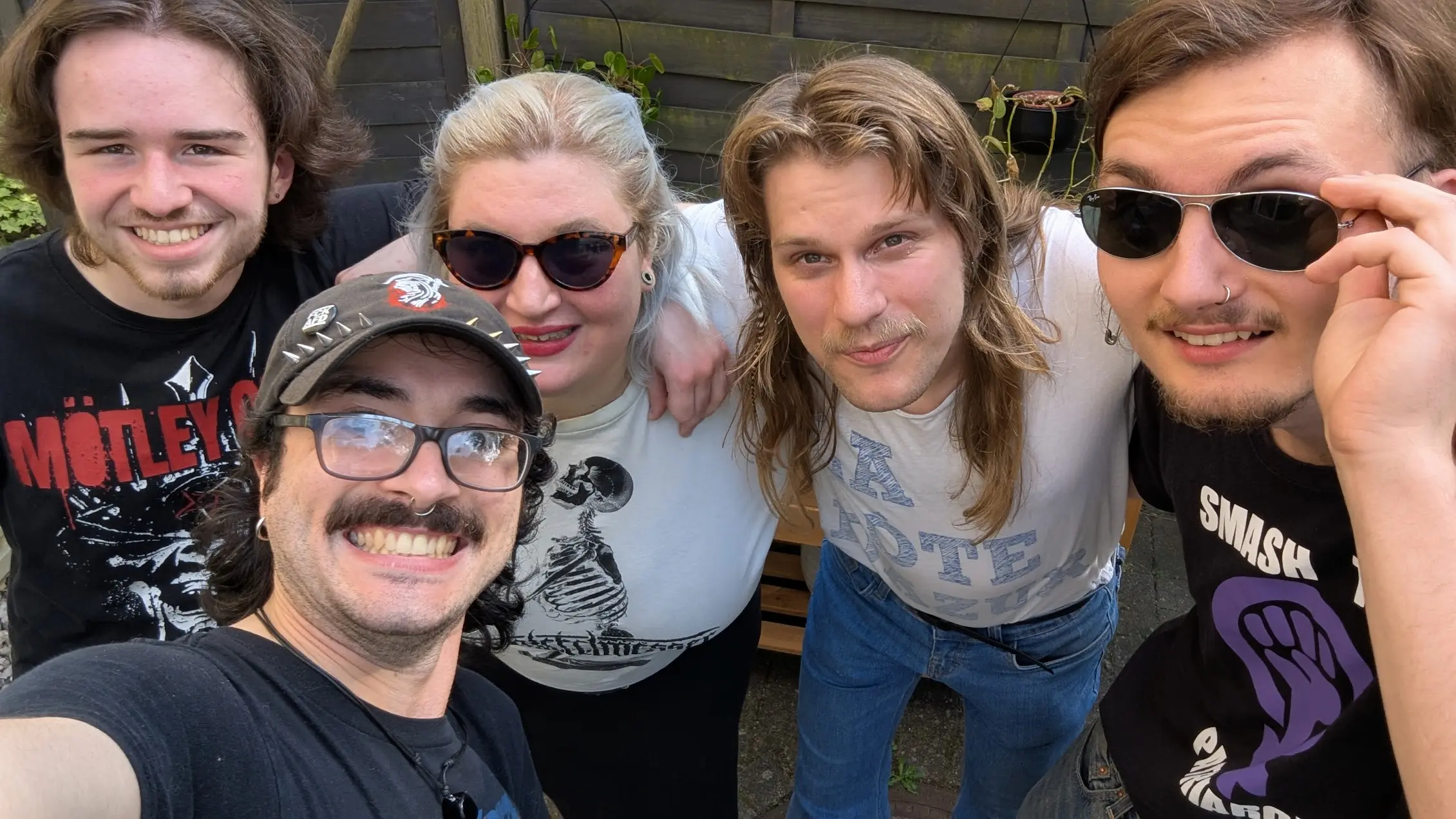 Bandfoto von DFF.
Es ist ein Selfie. Der, der die Kamera hält grinst breit, hinter ihm, Arm in Arm stehen vlnr ein Mann, eine Frau und noch zwei Männer. Sie alle lächeln in die Kamera und sehen gut gelaunt aus.