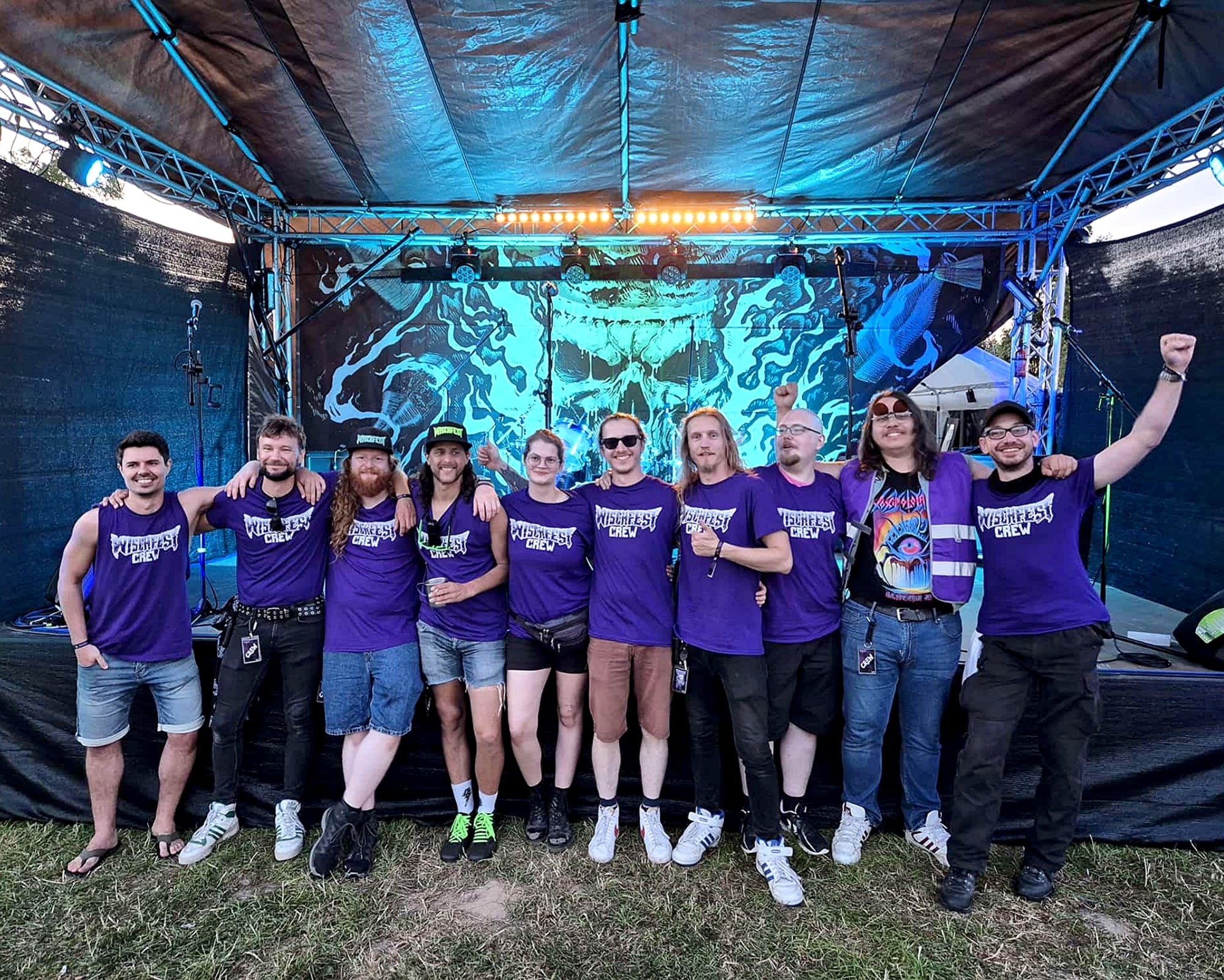 All but two of the Mopp Rulez club are standing in front of the Wischfest stage 2024.
Everyone wears purple T-shirts that say “Wischfest Crew” in white.